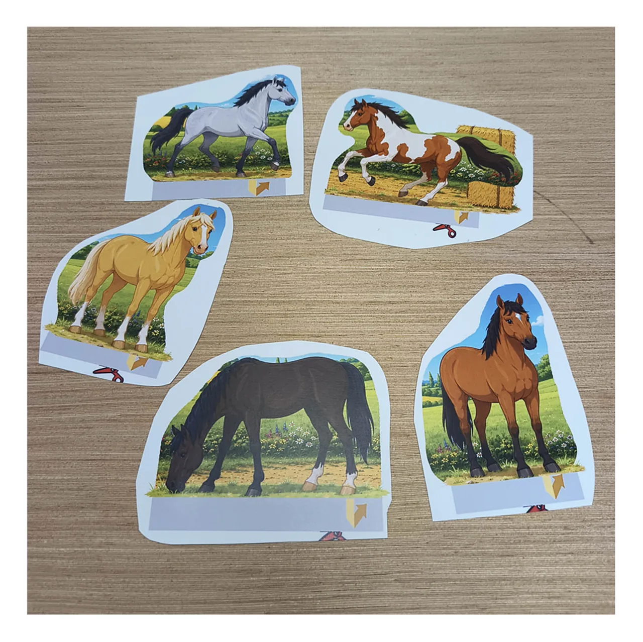 Five colorful printable paper horses cut out and ready to add to the horse stable and paddock diorama