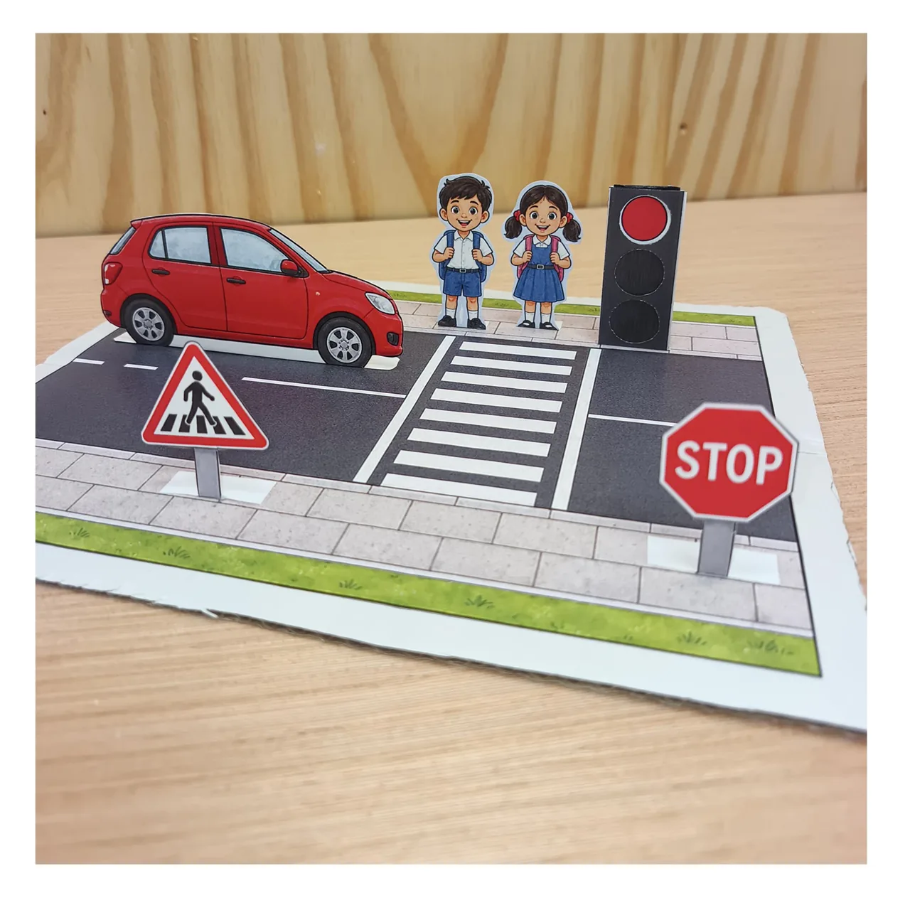 Experimental road safety school model with paper children, car, traffic light and zebra crossing