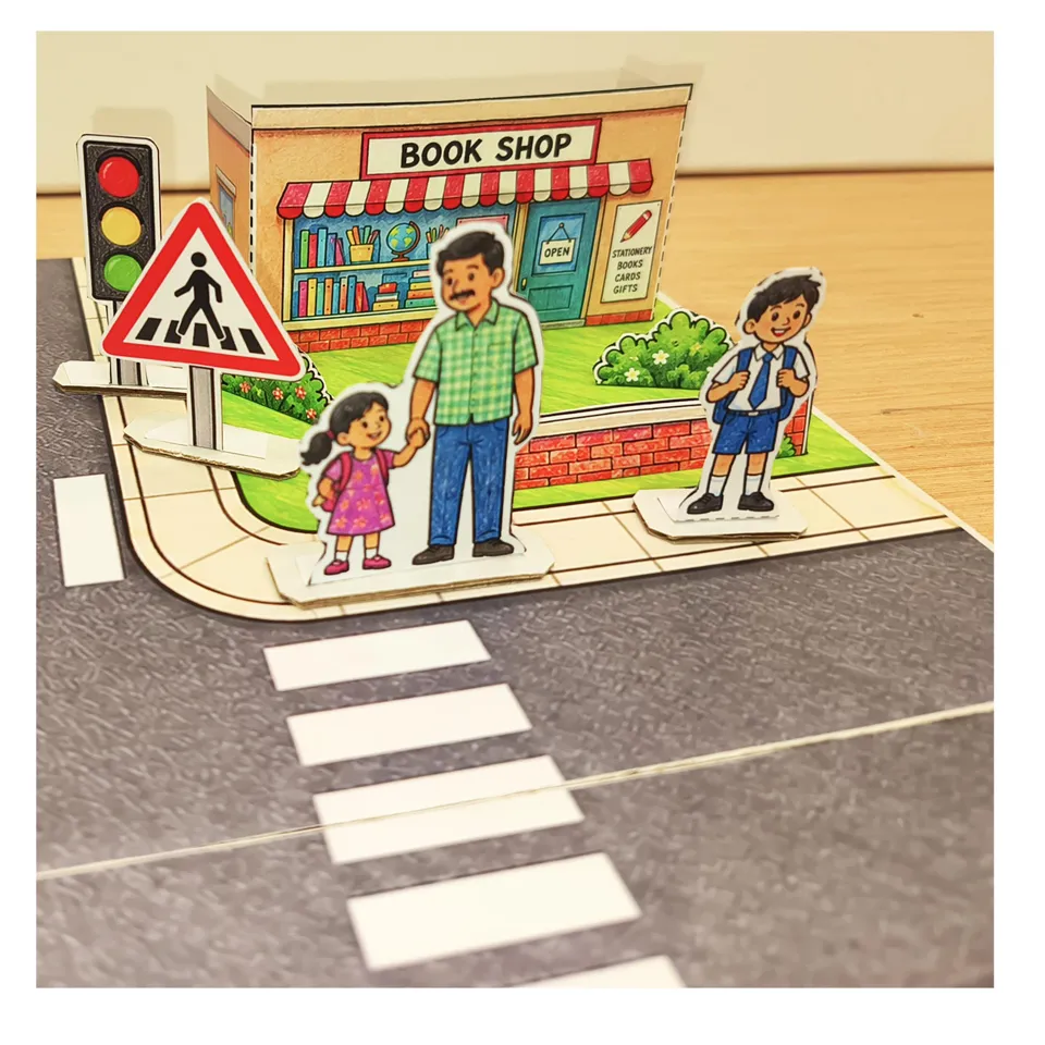 Paper pedestrians outside the bookshop beside a zebra crossing
