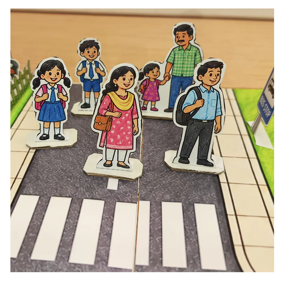 Indian schoolchildren and adults as standing paper figures by a zebra crossing