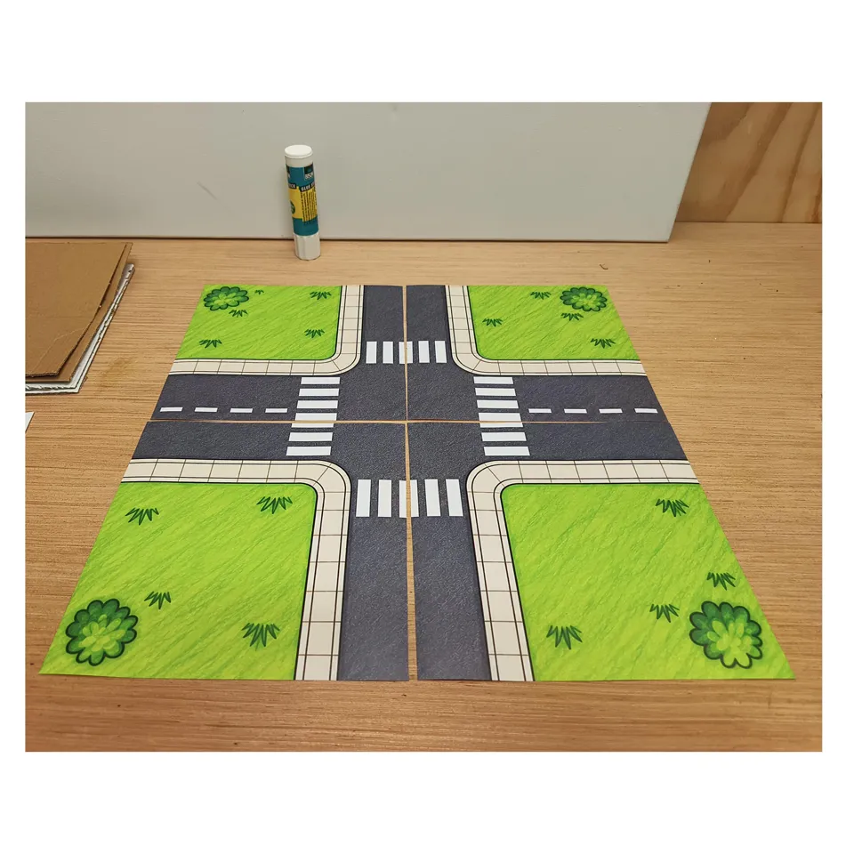 Four road sections arranged into a crossroads on a cardboard base