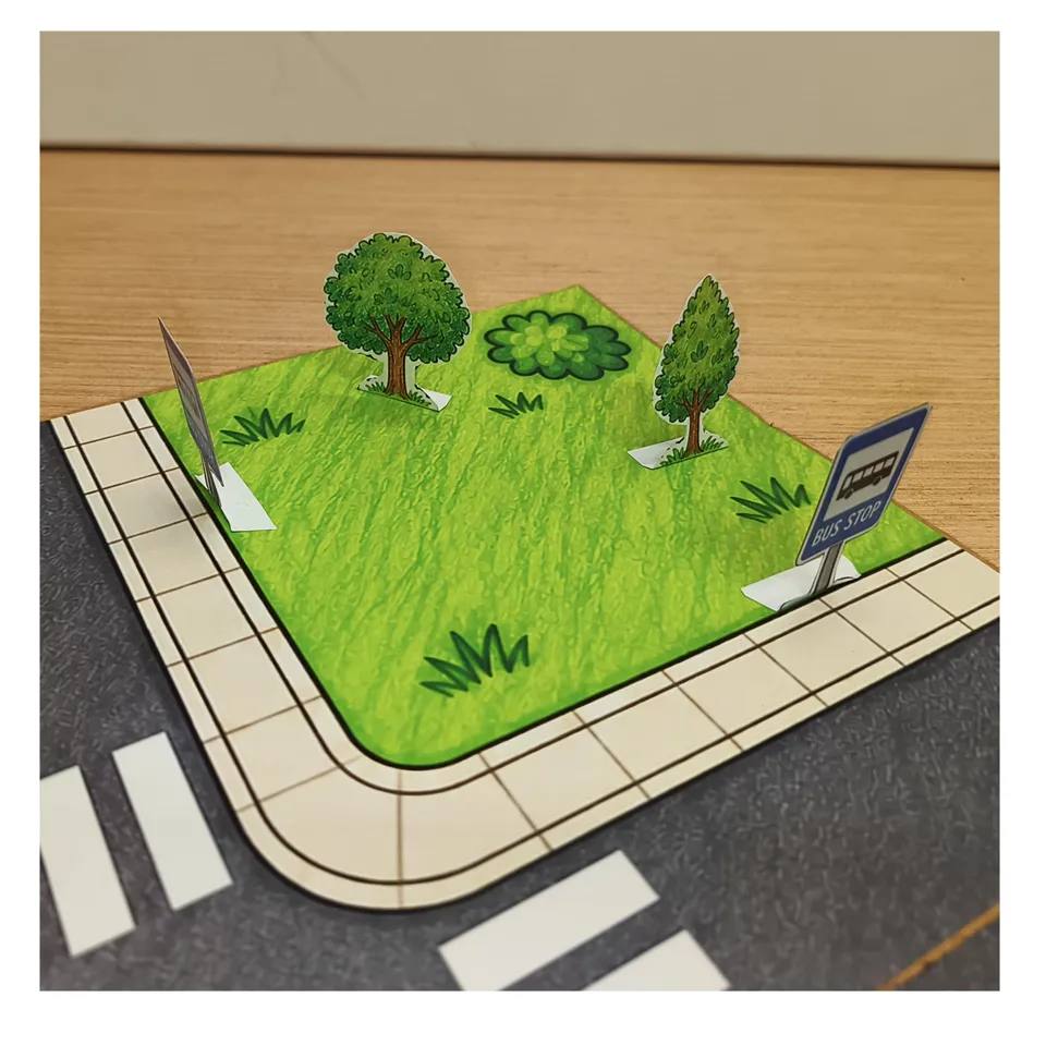 Paper trees on a green corner of the road safety model
