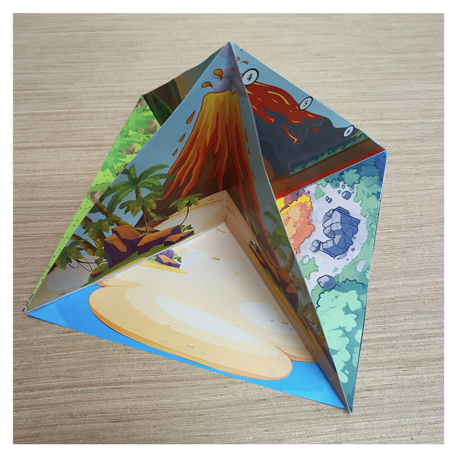 Assembled 3D paper volcano model for a school project, showing joined triangular sections with an island scene and numbered cross section