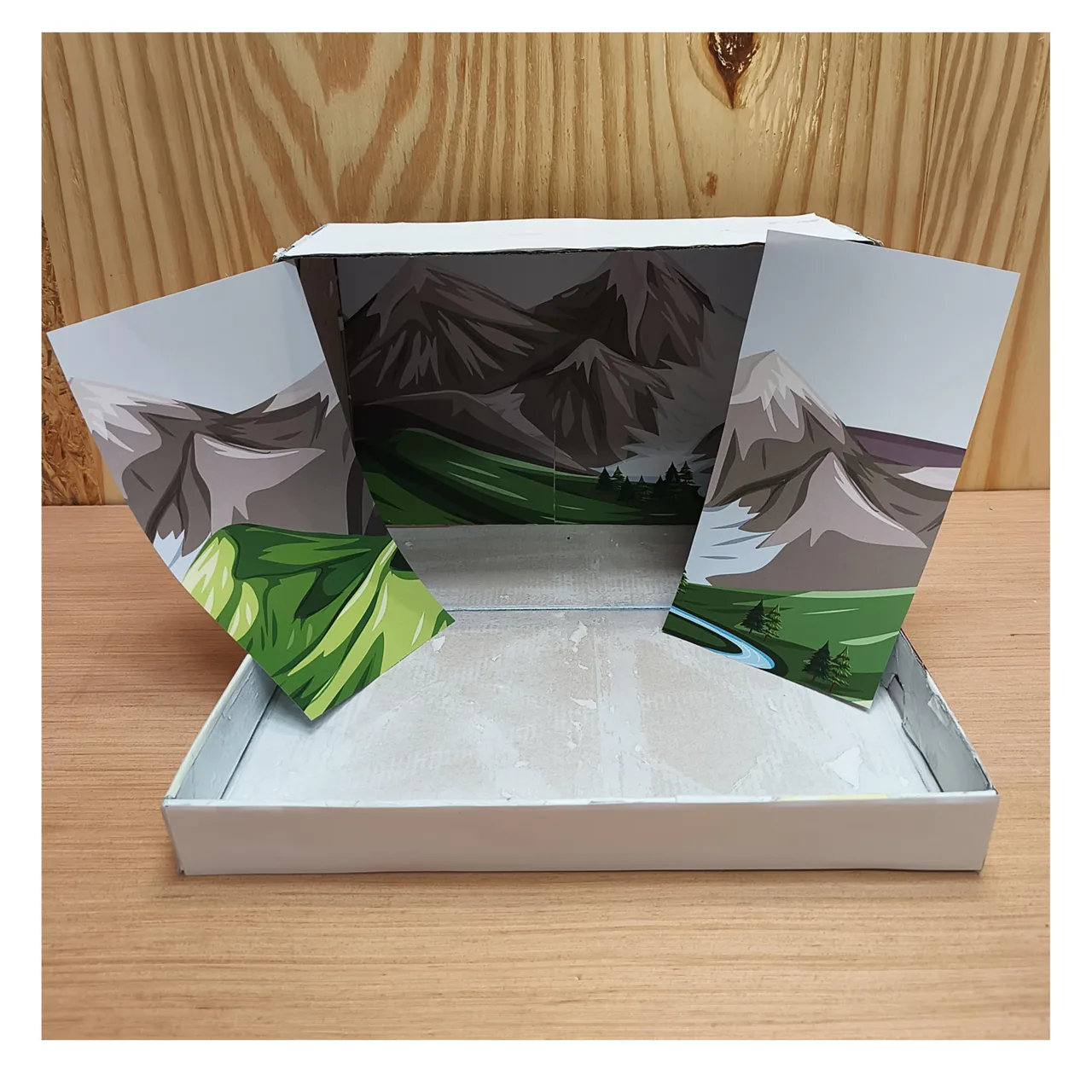 Mountain background panels being fitted inside an open shoebox
