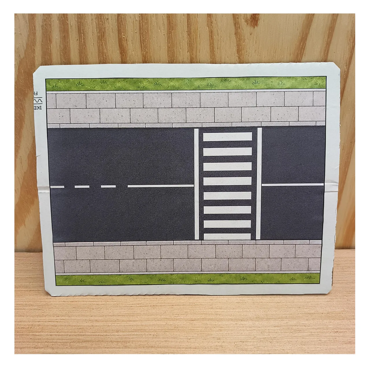 Zebra crossing road base mounted on cardboard, with pavements and grass strips.